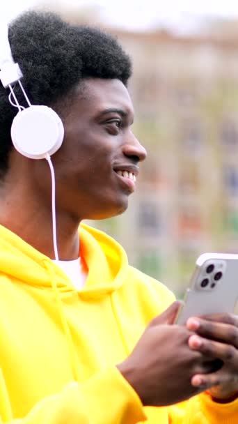 Elegante Joven Africano Bailando Mientras Escucha Música Con Auriculares Ciudad — Vídeo de stock