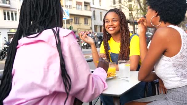 三位非洲女青年朋友在户外餐馆里喝啤酒 吃快餐 — 图库视频影像