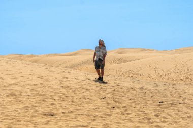 Yazın Maspalomalar, Gran Canaria, Kanarya Adaları 'nda yürüyen erkek turistin portresi