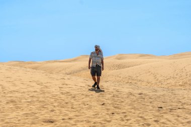 Yazın türbanlı turist Maspalomalar, Gran Kanarya Adaları, Kanarya Adaları 'nın kumullarında yürüyor.