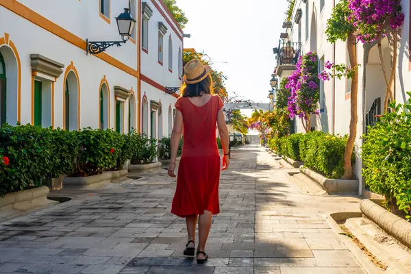 A woman walking in the port of the flower-filled coastal town Mogan in the south of Gran Canaria. Spain