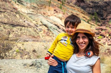 Anne ve oğlunun Mogan, Gran Canaria 'daki Doğal Anıt Azulejos de Veneguera ya da Gökkuşağı Kayaları' nda eğlenirken portresi