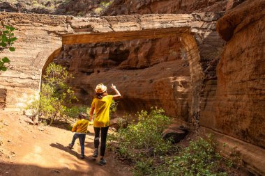 Kireçtaşı Kanarya Adaları 'ndaki Barranco de las Vacas Kanyonu' nda çocuğuyla birlikte bir kadın.