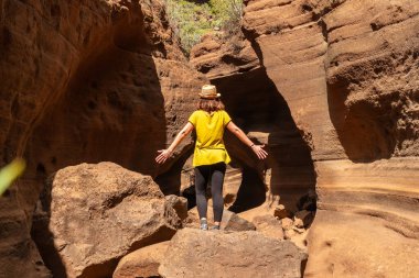 Kireçtaşı Kanarya Adaları 'ndaki Barranco de las Vacas kanyonunda şapkalı bir kadın.