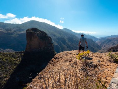 Gran Canaria, Kanarya Adaları 'ndaki Roque Nublo yakınlarındaki Roque Palmes perspektifinde bir yürüyüşçü