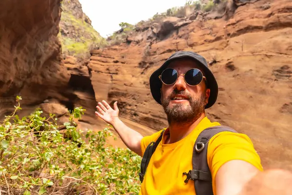 Mies Keltaisessa Paidassa Aurinkolaseissa Ottaa Selfien Kallion Eteen Käsite Seikkailu kuvapankin valokuva