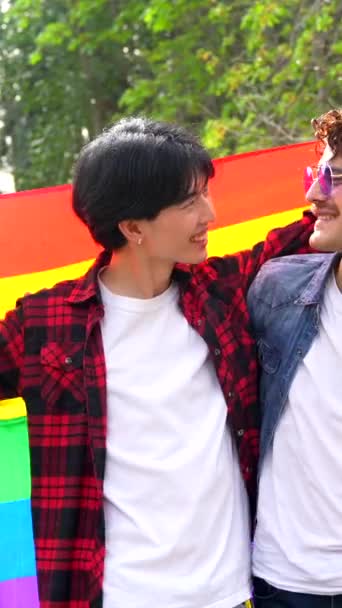 一个同性恋男性朋友在公园里升起Lgbt彩虹旗的低角度肖像 — 图库视频影像
