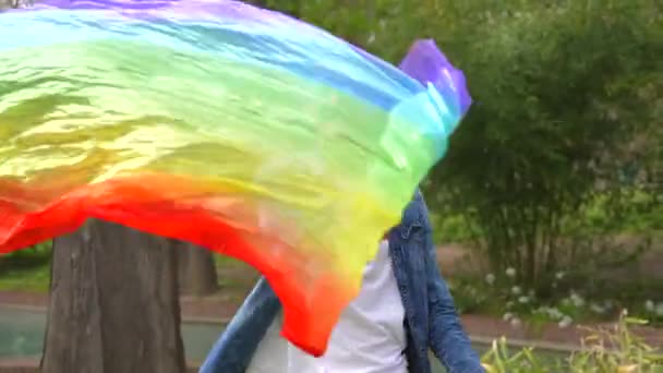 一个快乐而随意的男同性恋艺术家在公园里舞动彩虹扇子的动态镜头 — 图库视频影像