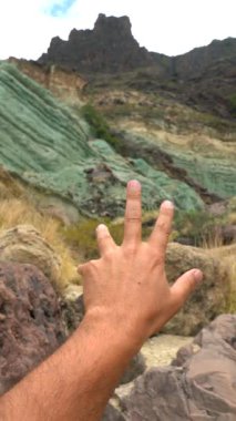 Mogan, Gran Canaria 'daki Azulejos de Veneguera ya da Gökkuşağı Kayalıkları' ndaki doğal anıtta bir adamın eli