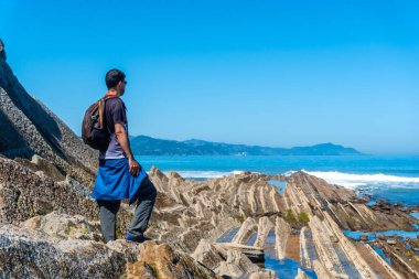 Zumaia, Gipuzkoa 'daki Flysch Basque Sahil Geopark' ta erkek bir yürüyüşçü.