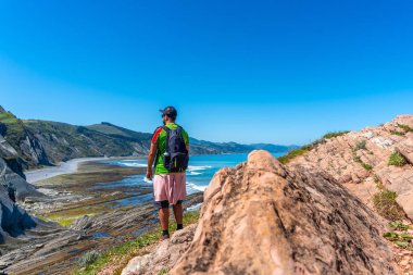 Zumaia, Gipuzkoa kıyısındaki Algorri Koyu 'nda yürüyüş yapan bir erkek. Bask Ülkesi