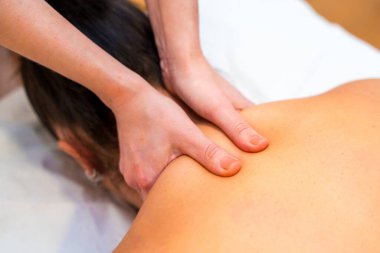 Bir hastaya boyun masajı yapan bir masözün üst görüntüsü.