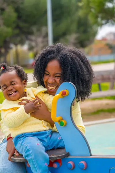 遊び場で楽しんでいる幸せなアフリカの母親と娘の垂直な3 4の長さの写真 — ストック写真