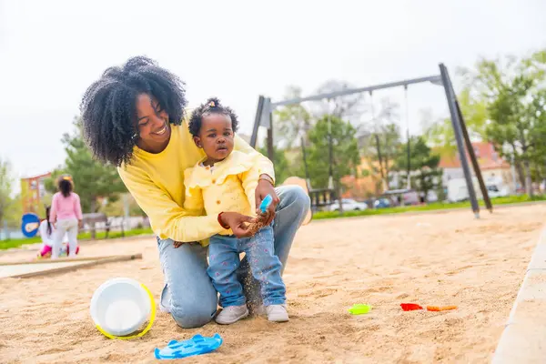 非洲母亲和女儿在公园的沙地上玩玩具 — 图库照片