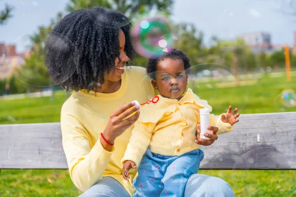 African Girl Lap Her Mother Playing Soap Bubbles Sitting Park — Stock Photo, Image
