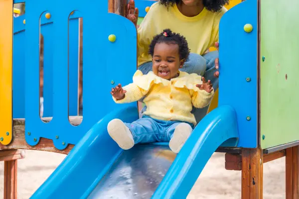 Baby Jente Skyve Blå Slide Park Med Sin Mor Ryggen – stockfoto