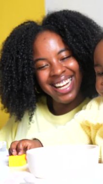 Mutlu Afrikalı anne ve tatlı bebek evdeki oturma odasında oynuyorlar.