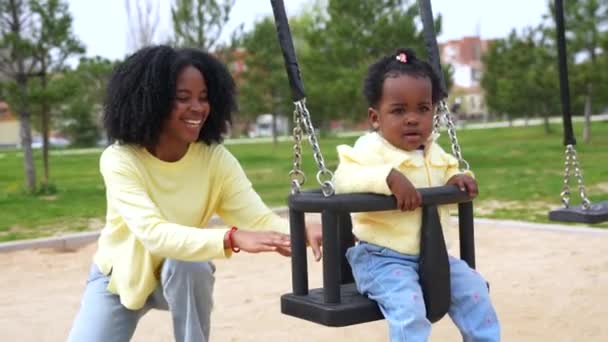 Sonriente Madre Africana Empujando Columpio Hija Parque — Vídeos de Stock