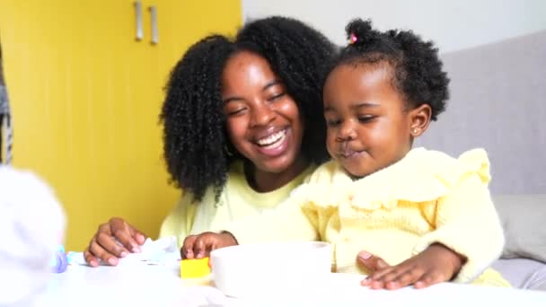 快乐的非洲母亲和可爱的幼儿在客厅里玩耍 免版税图库视频片段