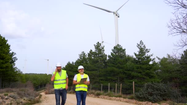 Yeşil Enerji Parkındaki Rüzgar Türbinlerini Inceleyen Teknisyenler Cep Telefonuyla Konuşuyor — Stok video