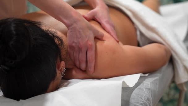 一位无法辨认的按摩师给躺在担架上的妇女做背部按摩的特写视频 — 图库视频影像