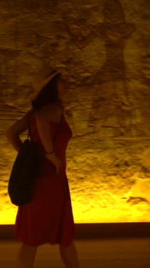 Genç bir turist, Mısır 'ın güneyindeki Abu Simbel tapınağında Nasser Gölü' nün yanındaki heykelleri ziyaret ediyor. Firavun 2. Ramss Tapınağı, 4k video