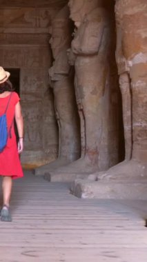 Genç bir turist, Mısır 'ın güneyindeki Abu Simbel tapınağında Nasser Gölü' nün yanındaki heykelleri ziyaret ediyor. Firavun 2. Ramss Tapınağı, 4k video