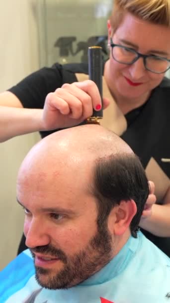 Penata Rambut Mencukur Kepala Seorang Pria Botak Untuk Memasang Wig — Stok Video