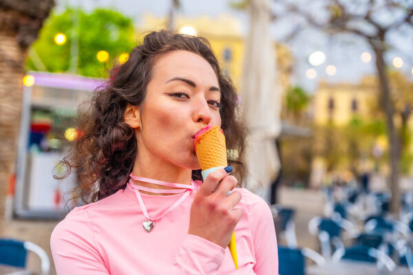 Close-up portrait of a caucasian sensual woman eating an ice cream in the city