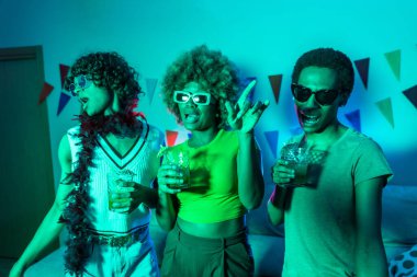 Gece partisinde dans eden ve alkol içen çok ırklı genç öğrenciler.