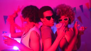 Havalı, etnik çeşitlilikte yetişkin insanlar kokteyl içip evde parti yapıyorlar.