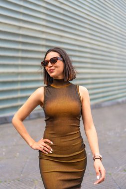 Şehirde neşeli ve gülümseyen çekici bir kadının orta boy portresi. Moda konsepti