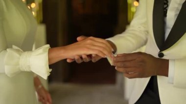 Zenci damat nikah gününde gelinine yüzük takıyor. Çok ırklı düğün