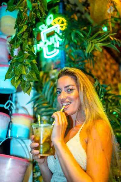 stock image Vertical photo of a sensual woman drinking mojito in a night bar