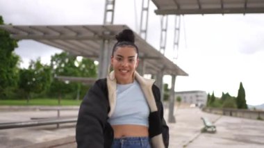 Mavi kotlu ve beyaz gömlekli bir kadın beton zeminde dans ediyor. Özgürlük ve neşe kavramı, çünkü kadın tamamen dansla meşgul.