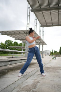 Kot pantolon ve beyaz gömlekli bir kadın dans ediyor ve elinde cep telefonu var. Özgürlük ve kendini ifade etme kavramı, kadın sadece dans etmekle kalmıyor, aynı zamanda telefonuyla da meşgul.