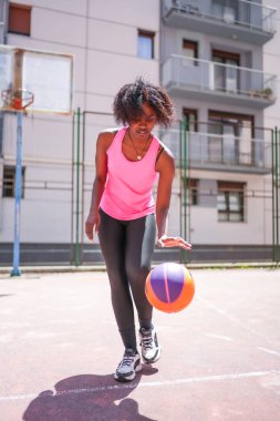 Şehirde basketbol oynayan Afrikalı genç bir kadının dikey uzunluğu