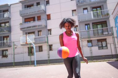Açık hava basketbol sahasında çalışan Afrikalı bir kadın.
