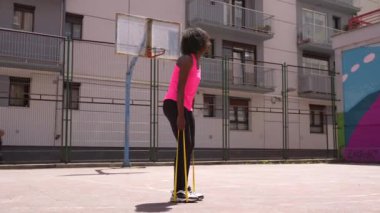 Genç Afrikalı formda bir kadın basketbol oynamadan önce bacaklarını açıyor