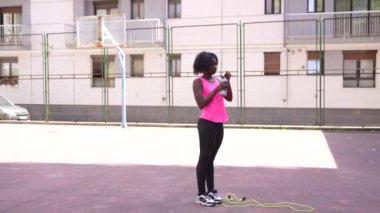 Açık havada basketbol oynayan Afrikalı Amerikalı bir kızın fotokopi çekilen yatay videosu.