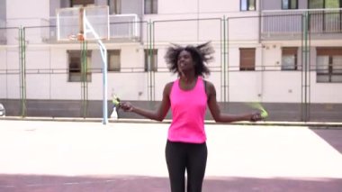 Açık havada basketbol oynayan Afrikalı bir kadının düşük açılı portresi.