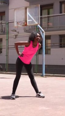 Açık hava basketbol sahasında ısınan Afrikalı bayan sporcu