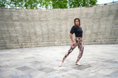 Parkta tutkulu bir şekilde dans eden Latin bir kadının tam boy fotokopi alanı.