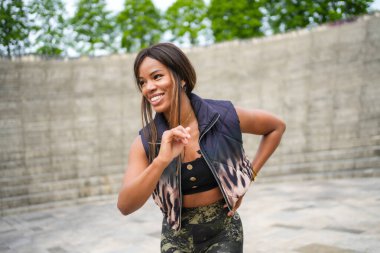 Parkta dans eden mutlu Latin bir kadının dörtte üçü kadar.