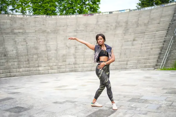 Stock image Horizontal full length photo with copy space of a joyful latin beauty woman dancing cuban salsa alone in a park