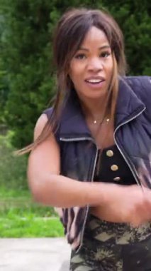 Güzel, tutkulu bir Latin kadının dikey portresi açık havada salsa yapıyor.