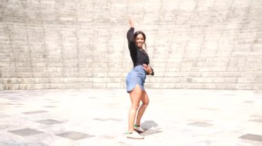 Latin güzel kadın parkta dans eden bir salsa hareketi yapıyor.