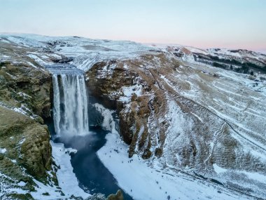 Donmuş Skogafoss şelalesinin insansız hava görüntüsü İzlanda 'da kışın karla doludur.