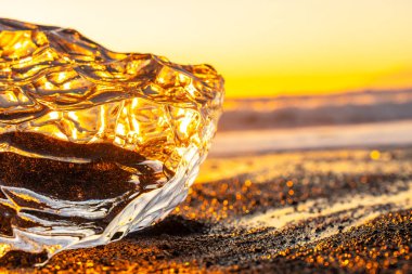 İzlanda 'da kış aylarında Jokulsarlon' un yanındaki Diamond Beach 'te gün doğumunda berrak buz.
