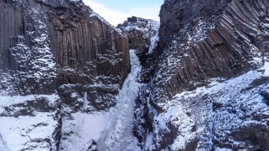 Güzel Hengifoss şelalesi İzlanda 'nın soğuk kışında donmuştu. Volkanik kayalıklar.